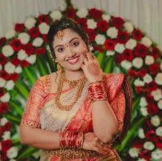 Bride smiling in front of a flower wall